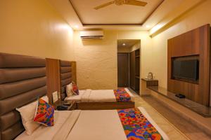 Habitación de hotel con 2 camas y TV de pantalla plana. en FabHotel Surya en Bhopal