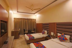 ボーパールにあるFabHotel Suryaのベッド2台とテーブルが備わるホテルルームです。