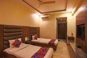 a hotel room with two beds and a television at FabHotel Surya in Bhopal