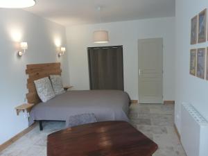 sypialnia z łóżkiem i drewnianym stołem w obiekcie La Maison d Antoine w mieście Tarascon-sur-Ariège