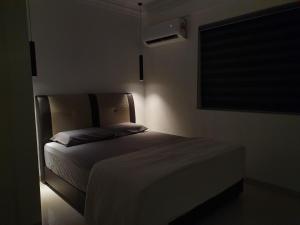 a bedroom with a bed in a dark room at Number A Homestay in Raub