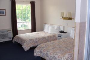 A bed or beds in a room at Leisure Inn