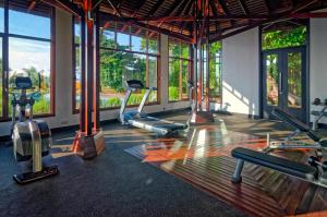 Borneo Eagle Resort في كوتا كينابالو: صالة ألعاب رياضية مع أجهزةالجري واجهزة الاوبتكال في غرفة بها نوافذ