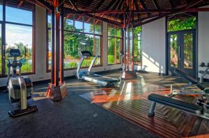 a gym with treadmills and ellipticals in a room with windows at Borneo Eagle Resort in Kota Kinabalu