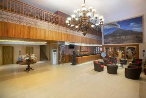 a lobby with a chandelier and couches in a building at Merapi Merbabu Hotels & Resorts in Yogyakarta