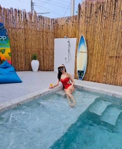 Eine Frau in einem roten Bikini, die im Pool sitzt. in der Unterkunft พีพี วิลล่า บางแสน รีสอร์ท in Ban Bang Saen (1)