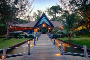 a wooden walkway leading to a house at Borneo Eagle Resort in Kota Kinabalu