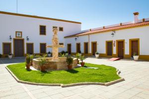 une cour avec une fontaine en face d'un bâtiment dans l'établissement Hotel Bodega el Moral, à Ribera del Fresno