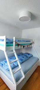two bunk beds in a room with a surfboard on top at Casa Basilea in Valbella
