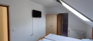 a bedroom with a bed and a tv on the wall at Olt-Part Vendégház in Băile Tuşnad