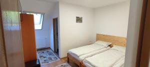 two beds in a small room with a window at Olt-Part Vendégház in Băile Tuşnad