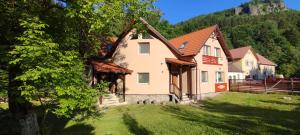 a house in the middle of a yard with trees at Olt-Part Vendégház in Băile Tuşnad