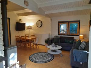 ein Wohnzimmer mit einem Sofa und einem Tisch in der Unterkunft 5 persoons chalet met gezellige houtkachel nabij Wildlands Emmen in Schoonebeek