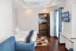une chambre d'hôtel avec un lit et un canapé bleu dans l'établissement Hotel Mega & Apartment, à Katmandou