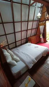 a large bed in a room with a wall at Bliss family cottage Batu in Batu