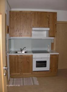una cucina con armadi in legno e lavandino di villa mahlfertheiner a Castelrotto