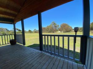 a porch of a cabin with a view of a field at Bretts Rest AZA in Kingscote