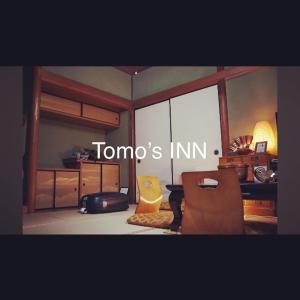 uma sala de estar com uma mesa e uma cadeira em Tomo's INN - priceless experience - em Obu