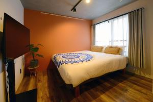 - une chambre avec un grand lit et une fenêtre dans l'établissement Luana Shibuya, à Tokyo