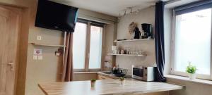 a kitchen with a table and a television in a room at La Maison Alsacienne in Kintzheim