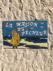 un cartello sul lato di un muro di La Maison du Pêcheur a Portbail
