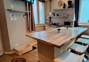 a kitchen with a large wooden counter top and chairs at La Maison Alsacienne in Kintzheim