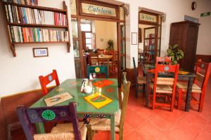 a dining room with a table and chairs and books at Posada del Cafeto in Xalapa