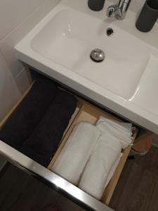 a drawer under a bathroom sink with towels in it at Home Up Bezons in Bezons