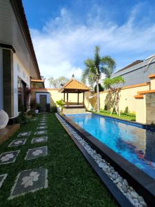 een zwembad in de tuin van een huis bij Villa Margherita in Seminyak