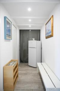 una camera con frigorifero bianco e panca di Casa Martesana a Milano