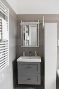 bagno con lavandino bianco e specchio di Casa Martesana a Milano