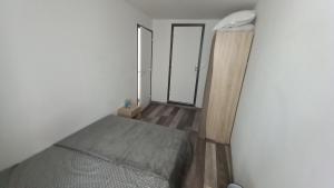 een kleine kamer met een bed en een spiegel bij Saint-flour appartement au cœur de la ville in Saint-Flour