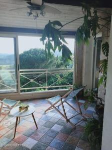 a room with two chairs and a table and a large window at Appartement au cœur du village de CALLIAN in Callian