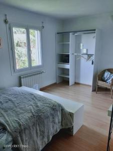 um quarto branco com uma cama e um frigorífico em Appartement au cœur du village de CALLIAN em Callian