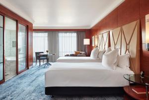 a hotel room with a large bed and a large window at Park Hyatt Melbourne in Melbourne
