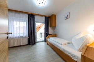 um quarto com uma cama e uma grande janela em Zeltweg-Rooms em Zeltweg