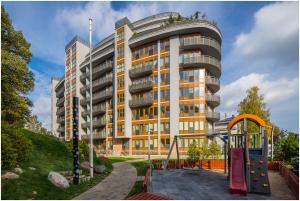 a large building with a playground in front of it at Klijanu street design studio in city centre in Riga