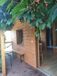 a wooden cabin with a bench on a deck at Jeleni Skok in Cisna