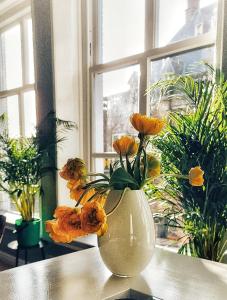 a vase filled with yellow flowers sitting on a table at Elf bed and breakfast in Bolsward