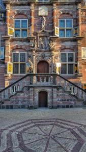 a large brick building with a staircase in front of it at Elf bed and breakfast in Bolsward +24 photos