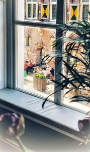 una ventana con vistas a una mesa y personas sentadas en mesas en Elf bed and breakfast, en Bolsward