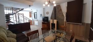 a living room with a couch and a tv and a staircase at Casa Melitona in Castiello de Jaca