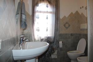 ブドーニにあるCasa vacanza Tanaunellaのバスルーム(洗面台、トイレ付)、窓が備わります。