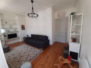 salon z niebieską kanapą i dywanem w obiekcie Le TAYLOR Hypercentre, Spacieux & Lumineux w mieście Pau