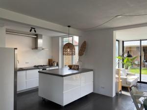 une cuisine avec des placards blancs et un comptoir dans l'établissement Air Beach & Sea Villa Unieke locatie, à Zandvoort