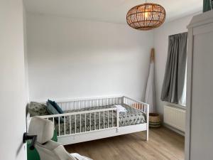 - un lit bébé blanc dans une chambre blanche dans l'établissement Air Beach & Sea Villa Unieke locatie, à Zandvoort
