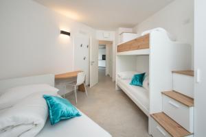 sypialnia z 2 łóżkami piętrowymi i biurkiem w obiekcie Suite Butterfly - dolce vita at lake garda w mieście Riva del Garda