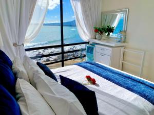 a hotel room with a large window overlooking the ocean at 185 on BEACH Boutique Suites in Gordonʼs Bay