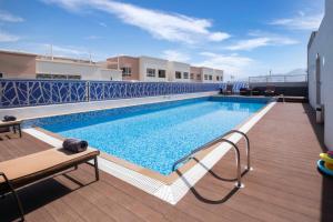 a swimming pool on the roof of a building at Citadines Al Ghubrah Muscat in Muscat