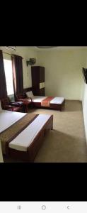 um quarto de hotel com duas camas e uma mesa em Motel TÂY HỒ em Haiphong